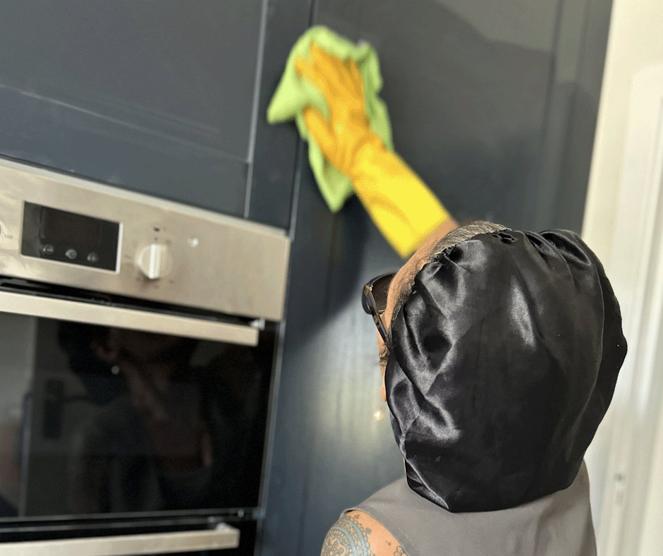 A woman cleaning the front os a kitchen unit